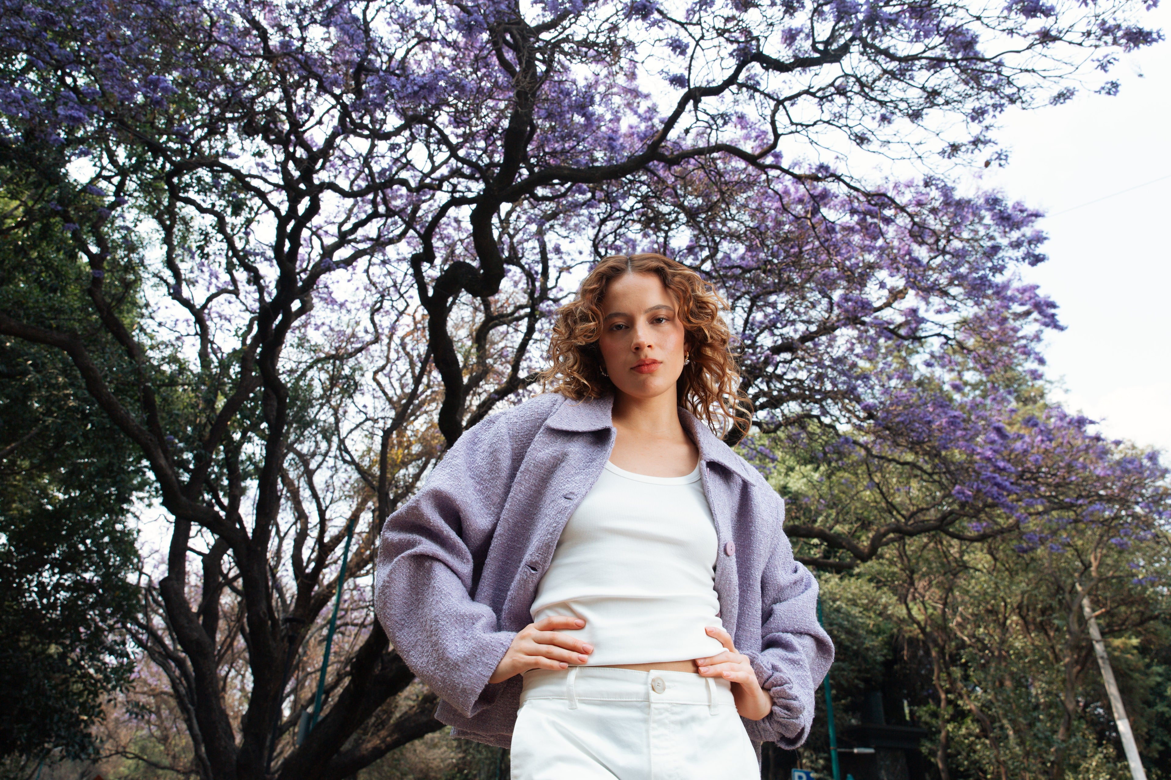 Woman standing in a park with purple flowering trees